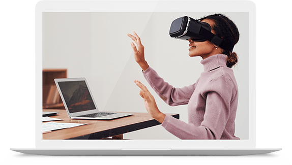 Woman using virtual reality headset near laptop