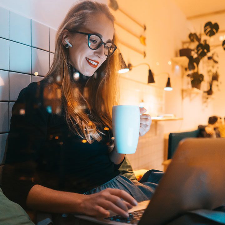 Woman working on laptop in cosy café