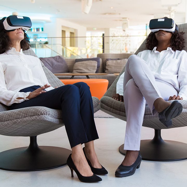 Women relaxing in chairs using virtual reality headsets