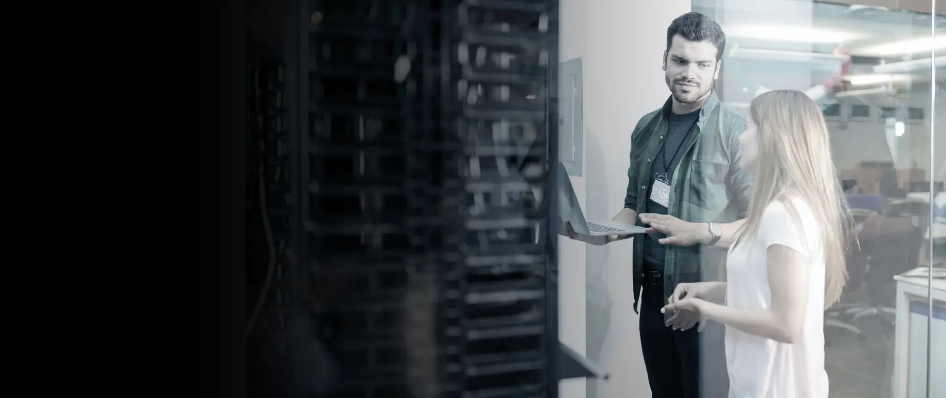 Team of IT professionals working at computer monitors in a modern data center