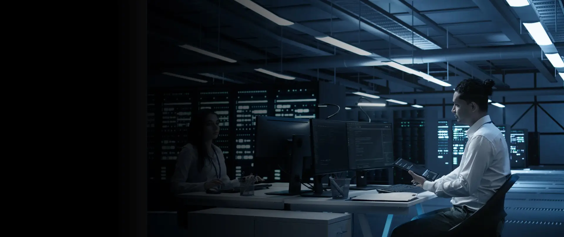 IT professionals monitoring servers and data on multiple screens inside a secure data center environment